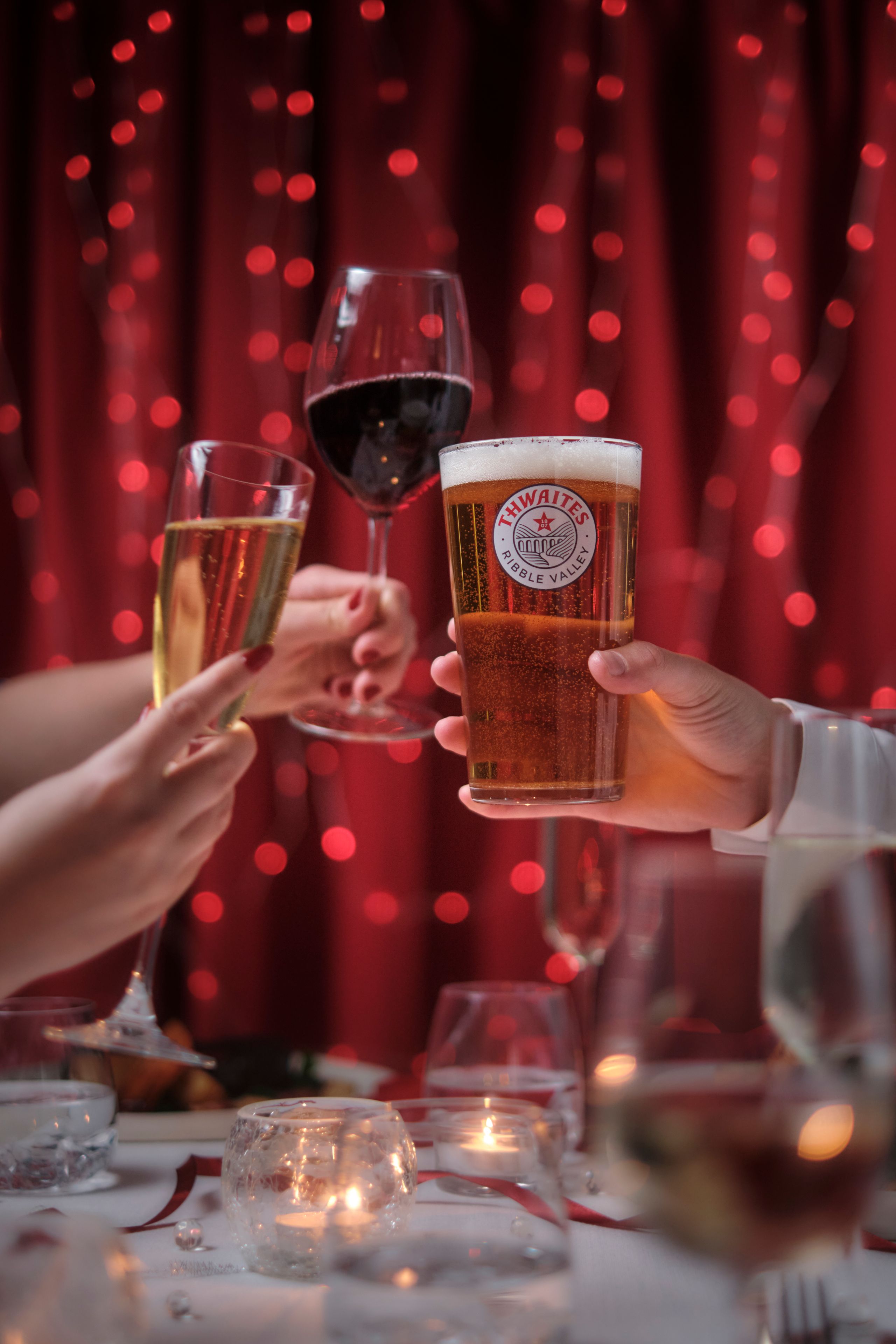 Pint of beer, red wine and champagne cheersing