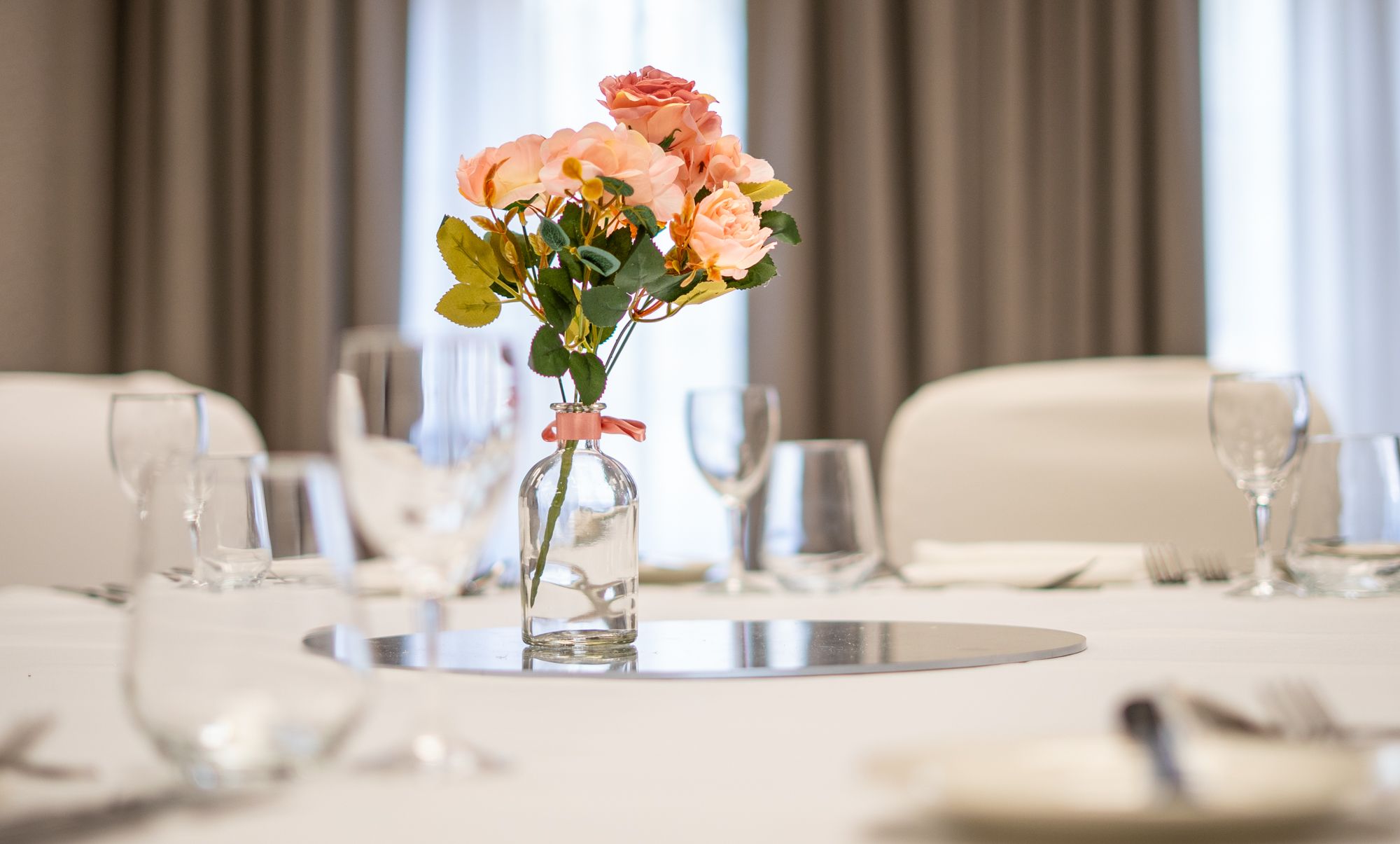 Pink flower centrepiece on white dressed table